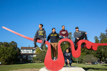 five students sitting around a sculpture