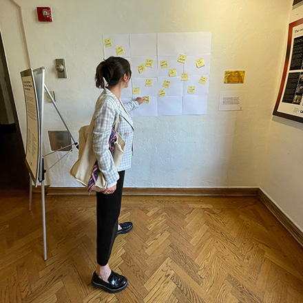 Woman pointing at part of the wall at the exhibit