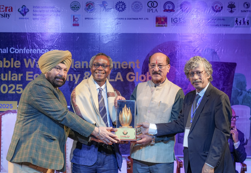 Dele receiving an award at Graphic Era University.