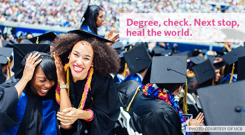 Two women excited to graduate in front of their graduating class.