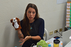 Lauren Haack with a dog puppet on her hand