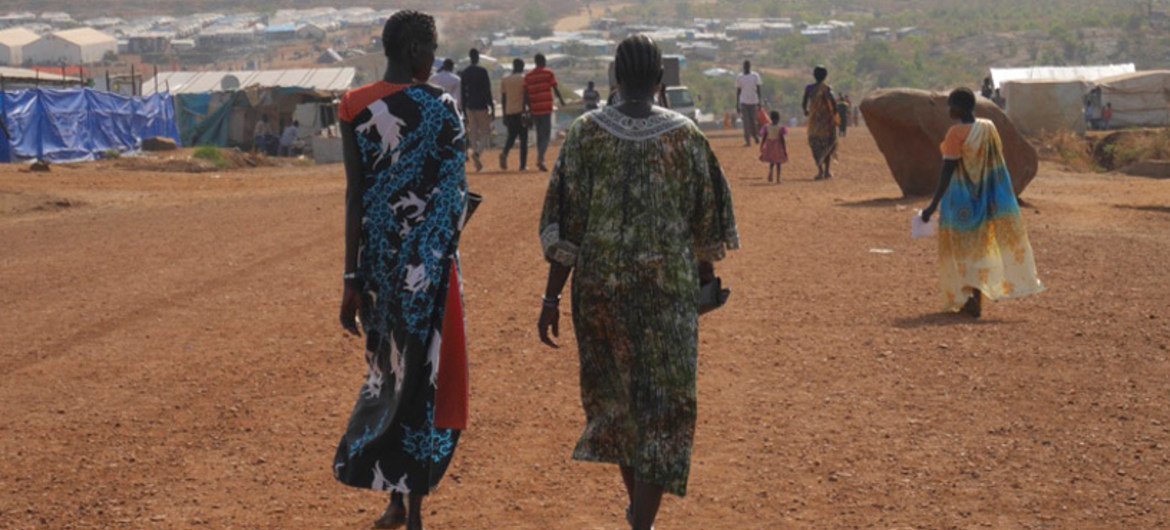 Photo by UNAIDS of two women walking in a refugee camp